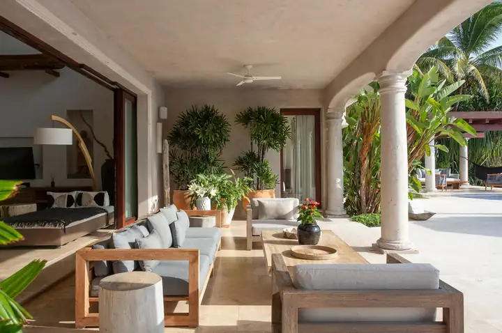 The covered terrace living room opening onto the pool deck