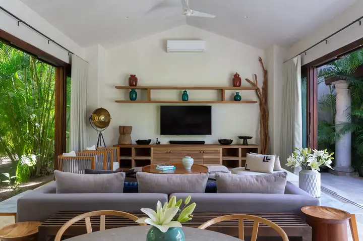 The family room with sofas and a television, opening to the garden