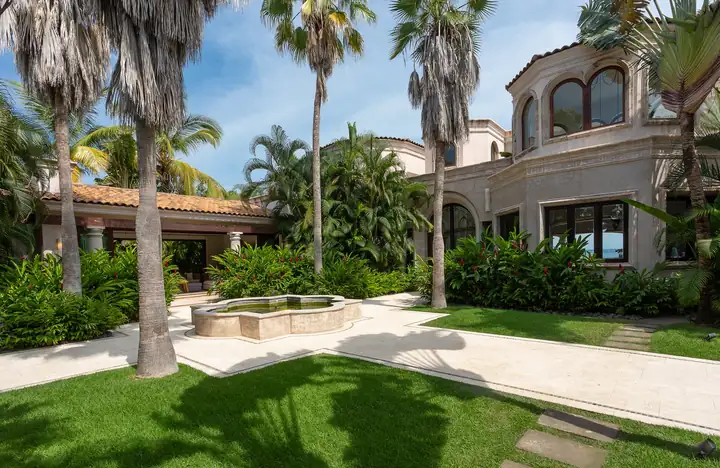 The garden lawn, palms and fountain at the entrance