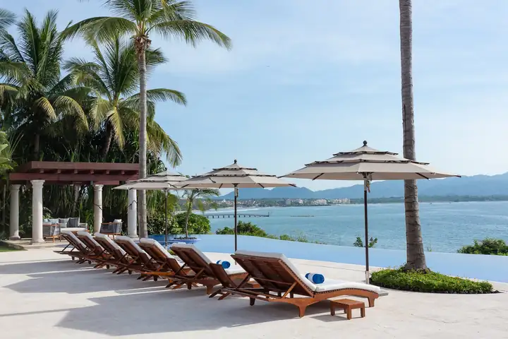 A row of loungers facing the bay, the far shore in the distance