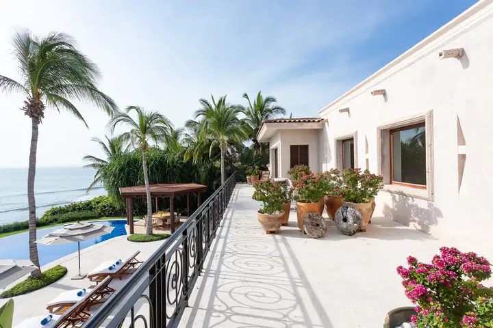 The wrought-iron railing of the upper terrace above the pool